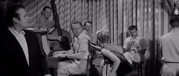 Movie still from “The Three Faces of Eve” (1957), directed by Nunnally Johnson – An old black and white photo of a man and a woman; Medium shot, High angle