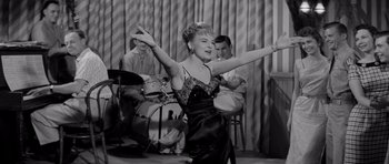 Movie still from “The Three Faces of Eve” (1957), directed by Nunnally Johnson – A woman in a black and white photo is dancing; Medium shot, Low angle