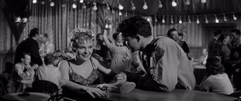 Movie still from “The Three Faces of Eve” (1957), directed by Nunnally Johnson – A man and a woman sitting at a table; Medium shot, Low angle