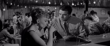 Movie still from “The Three Faces of Eve” (1957), directed by Nunnally Johnson – A man and a woman sitting at a table in front of each other; Medium shot, Low angle