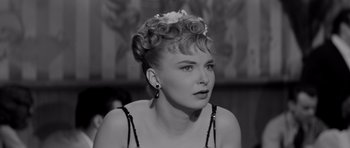 Movie still from “The Three Faces of Eve” (1957), directed by Nunnally Johnson – A black and white photo of a woman with a flower in her hair; Close Up shot, Over the shoulder angle