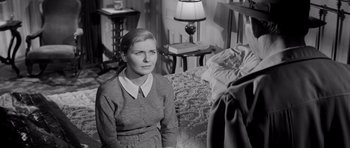 Movie still from “The Three Faces of Eve” (1957), directed by Nunnally Johnson – A woman sitting on a bed in front of a lamp; Medium shot, High angle