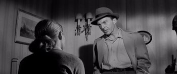 Movie still from “The Three Faces of Eve” (1957), directed by Nunnally Johnson – An old photo of a man talking to a woman; Medium shot, Over the shoulder angle