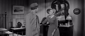 Movie still from “The Three Faces of Eve” (1957), directed by Nunnally Johnson – A man and a woman shaking hands in a room; Medium shot, Over the shoulder angle
