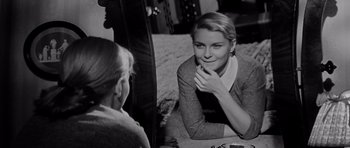 Movie still from “The Three Faces of Eve” (1957), directed by Nunnally Johnson – A woman sitting next to another woman on a couch; Close Up shot, Over the shoulder angle