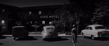 Movie still from “The Three Faces of Eve” (1957), directed by Nunnally Johnson – An old car parked in front of the dixie motel; Extreme Wide shot, Low angle