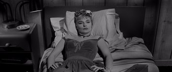 Movie still from “The Three Faces of Eve” (1957), directed by Nunnally Johnson – A black and white photo of a woman laying in a bed; Medium shot, High angle