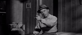 Movie still from “The Three Faces of Eve” (1957), directed by Nunnally Johnson – A man wearing a hat is holding a cigarette; Medium shot, Low angle