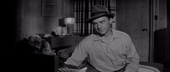 Movie still from “The Three Faces of Eve” (1957), directed by Nunnally Johnson – A black and white photo of a man wearing a hat; Medium shot, Over the shoulder angle