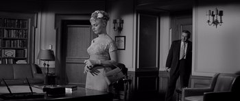 Movie still from “The Three Faces of Eve” (1957), directed by Nunnally Johnson – A black and white photo of a woman holding a purse; Medium shot, Low angle