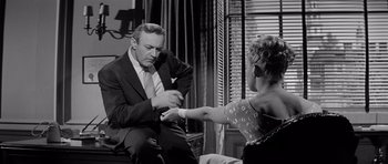 Movie still from “The Three Faces of Eve” (1957), directed by Nunnally Johnson – A man and a woman are sitting in a living room; Medium shot, Low angle