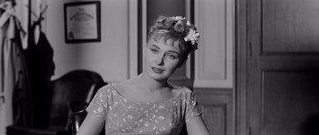 Movie still from “The Three Faces of Eve” (1957), directed by Nunnally Johnson – A black and white photo of a woman with a flower in her hair; Close Up shot, Over the shoulder angle