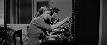 Movie still from “The Three Faces of Eve” (1957), directed by Nunnally Johnson – A group of women working in an electrical room; Medium shot, Low angle