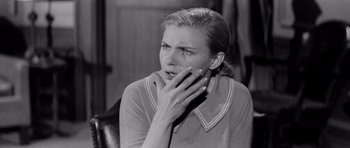 Movie still from “The Three Faces of Eve” (1957), directed by Nunnally Johnson – An old photo of a woman holding her hand to her face; Close Up shot, Low angle