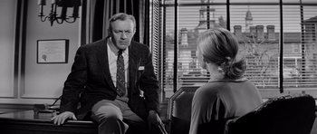 Movie still from “The Three Faces of Eve” (1957), directed by Nunnally Johnson – An older man and a young woman sitting in front of a window; Medium shot, Over the shoulder angle