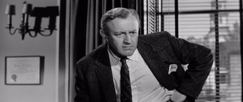 Movie still from “The Three Faces of Eve” (1957), directed by Nunnally Johnson – An older man in a suit and tie; Close Up shot, Over the shoulder angle