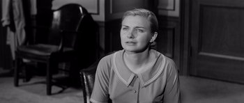 Movie still from “The Three Faces of Eve” (1957), directed by Nunnally Johnson – An older woman sitting in a chair in front of a desk; Close Up shot, Low angle