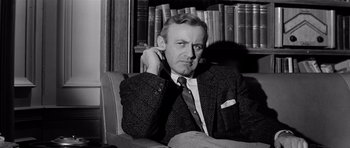 Movie still from “The Three Faces of Eve” (1957), directed by Nunnally Johnson – An older man sitting in a chair with his hand on his ear; Close Up shot, Low angle