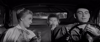 Movie still from “The Three Faces of Eve” (1957), directed by Nunnally Johnson – Two people sitting in the back seat of a car eating ice cream cones; Medium shot, High angle