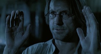 Movie still from “The Ugly Swans” (2006), directed by Konstantin Lopushanskiy – A person wearing glasses and a white shirt; Close Up shot, Over the shoulder angle