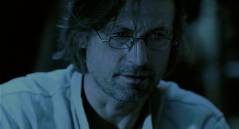 Movie still from “The Ugly Swans” (2006), directed by Konstantin Lopushanskiy – A person wearing glasses and a white shirt; Close Up shot, Over the shoulder angle