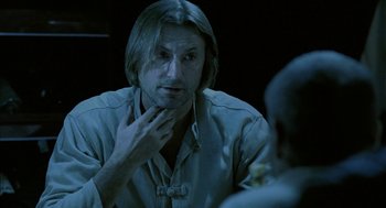 Movie still from “The Ugly Swans” (2006), directed by Konstantin Lopushanskiy – A man sitting in front of another man in front of a mirror; Close Up shot, Over the shoulder angle