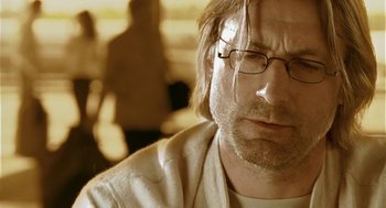 Movie still from “The Ugly Swans” (2006), directed by Konstantin Lopushanskiy – A person wearing glasses and a white shirt; Close Up shot, Low angle