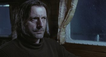 Movie still from “The Ugly Swans” (2006), directed by Konstantin Lopushanskiy – A person sitting in a chair; Close Up shot, Low angle