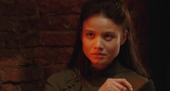 Movie still from “The Ugly Swans” (2006), directed by Konstantin Lopushanskiy – A young woman with long dark brown hair wearing a green shirt; Close Up shot, Over the shoulder angle