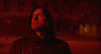 Movie still from “The Ugly Swans” (2006), directed by Konstantin Lopushanskiy – A man wearing a hooded jacket looking up at the sky; Close Up shot, Low angle