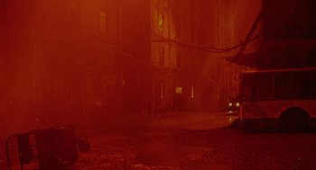 Movie still from “The Ugly Swans” (2006), directed by Konstantin Lopushanskiy – A street scene with a person standing on the sidewalk; Extreme Wide shot, High angle