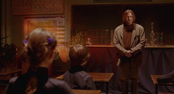 Movie still from “The Ugly Swans” (2006), directed by Konstantin Lopushanskiy – A man standing in front of a group of people; Medium shot, Over the shoulder angle