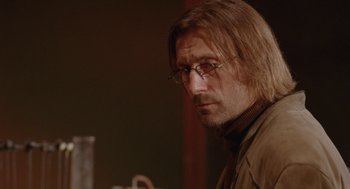 Movie still from “The Ugly Swans” (2006), directed by Konstantin Lopushanskiy – A person wearing glasses; Close Up shot, Over the shoulder angle