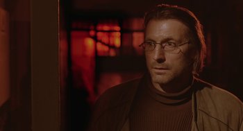 Movie still from “The Ugly Swans” (2006), directed by Konstantin Lopushanskiy – A person wearing glasses and a sweater; Close Up shot, Low angle