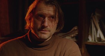 Movie still from “The Ugly Swans” (2006), directed by Konstantin Lopushanskiy – A person wearing a brown sweater; Close Up shot, Low angle