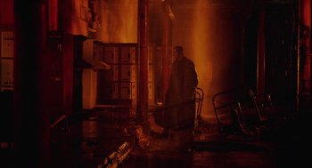 Movie still from “The Ugly Swans” (2006), directed by Konstantin Lopushanskiy – A man standing next to a fire hydrant in a room; Extreme Wide shot, Low angle
