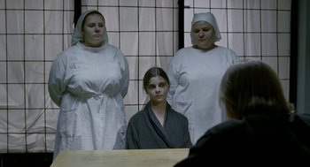 Movie still from “The Ugly Swans” (2006), directed by Konstantin Lopushanskiy – A group of women standing next to each other in front of a mirror; Medium shot, Over the shoulder angle