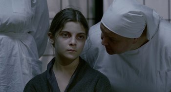Movie still from “The Ugly Swans” (2006), directed by Konstantin Lopushanskiy – A young girl is being comforted by an older man; Close Up shot, Over the shoulder angle