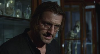 Movie still from “The Ugly Swans” (2006), directed by Konstantin Lopushanskiy – A person wearing glasses and a black shirt; Close Up shot, Over the shoulder angle