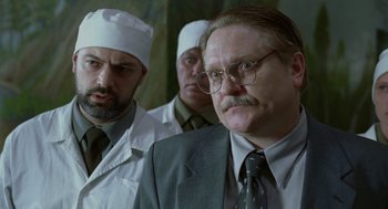 Movie still from “The Ugly Swans” (2006), directed by Konstantin Lopushanskiy – A group of men standing next to each other in a room; Close Up shot, Over the shoulder angle
