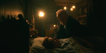 Movie still from “The Umbrella Academy” (2019), created by Steve Blackman – An older man leaning over a young man in a hospital bed; Medium shot, Over the shoulder angle