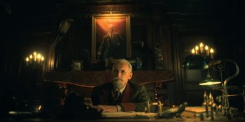 Movie still from “The Umbrella Academy” (2019), created by Steve Blackman – An older man sitting at a desk in front of a painting; Medium shot, Low angle