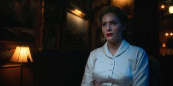 Movie still from “The Umbrella Academy” (2019), created by Steve Blackman – A woman in a white shirt is standing in a dark room; Close Up shot, Low angle