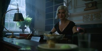 Movie still from “The Umbrella Academy” (2019), created by Steve Blackman – A woman sitting at a table with a plate in front of her; Medium shot, Over the shoulder angle