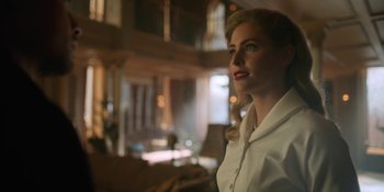 Movie still from “The Umbrella Academy” (2019), created by Steve Blackman – A woman in a white shirt is looking to her left; Medium shot, Low angle