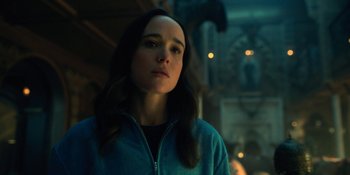 Movie still from “The Umbrella Academy” (2019), created by Steve Blackman – A woman with long brown hair standing in front of a building; Close Up shot, Over the shoulder angle