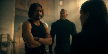 Movie still from “The Umbrella Academy” (2019), created by Steve Blackman – A man standing next to another man in a room; Medium shot, Over the shoulder angle