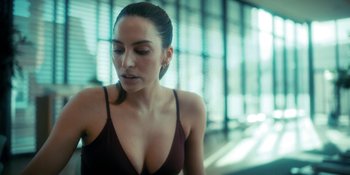 Movie still from “The Umbrella Academy” (2019), created by Steve Blackman – A beautiful woman in a brown top looking at the camera; Close Up shot, Over the shoulder angle
