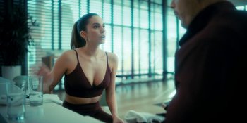 Movie still from “The Umbrella Academy” (2019), created by Steve Blackman – A beautiful young woman wearing a brown bra; Close Up shot, Over the shoulder angle