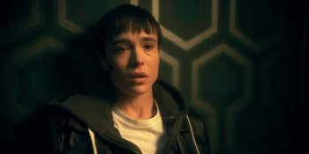 Movie still from “The Umbrella Academy” (2019), created by Steve Blackman – A young man with a black jacket is looking at the camera; Close Up shot, High angle